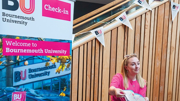 Jess, a student ambassador, showing an Open Day guide book to a visitor